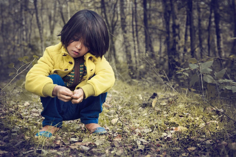 a little girl kneeling down and touching soing