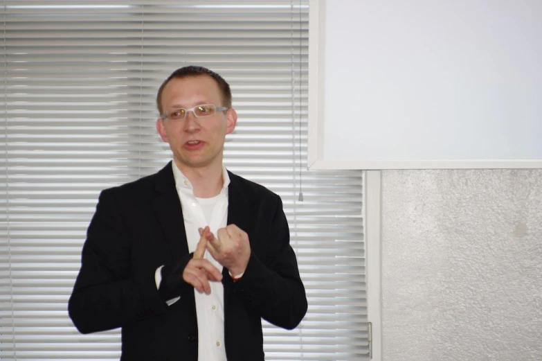 a man in glasses making the sign of nom