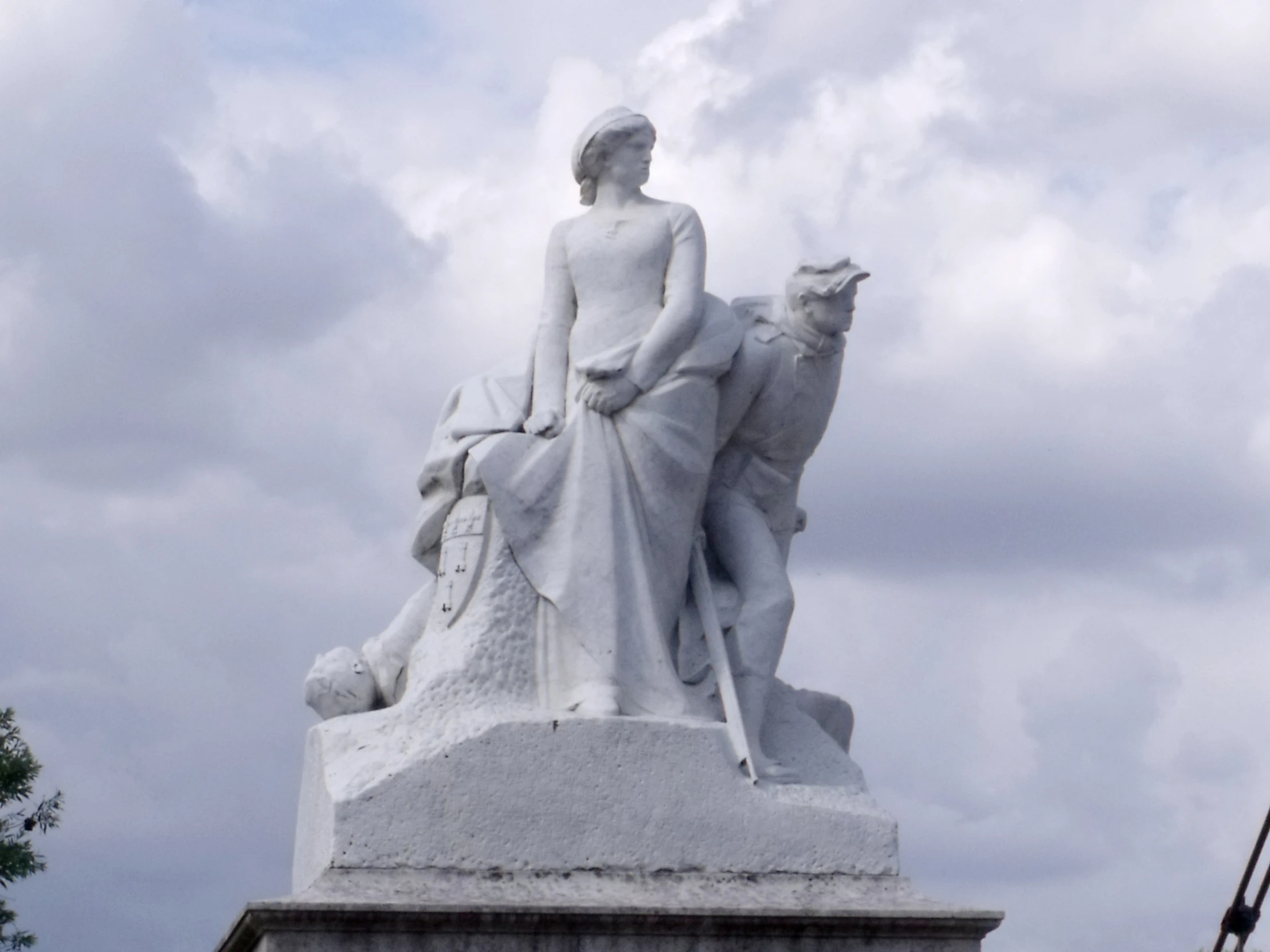 a white statue on top of a pedestal under clouds