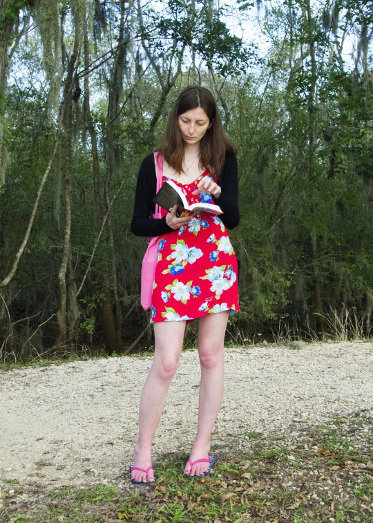 a woman in a red and white dress standing in the dirt