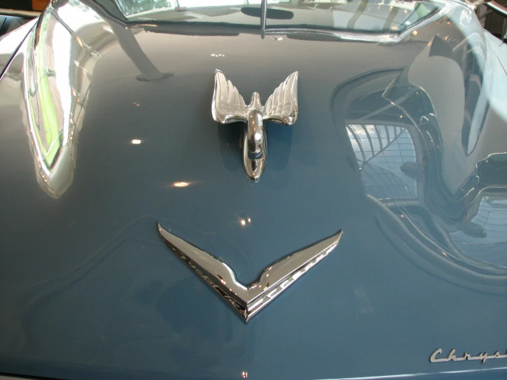 two hood ornaments are on the back of a car