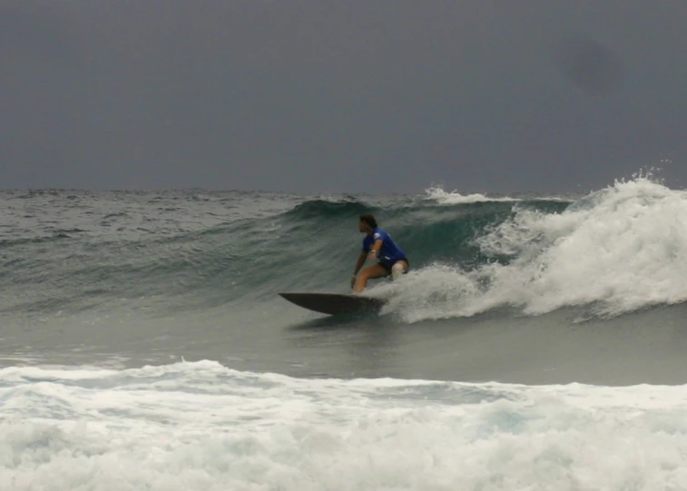 a man riding on top of a surfboard on a wave