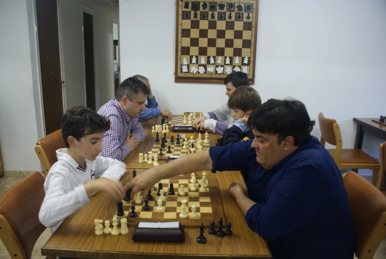 group of men sitting at table playing chess