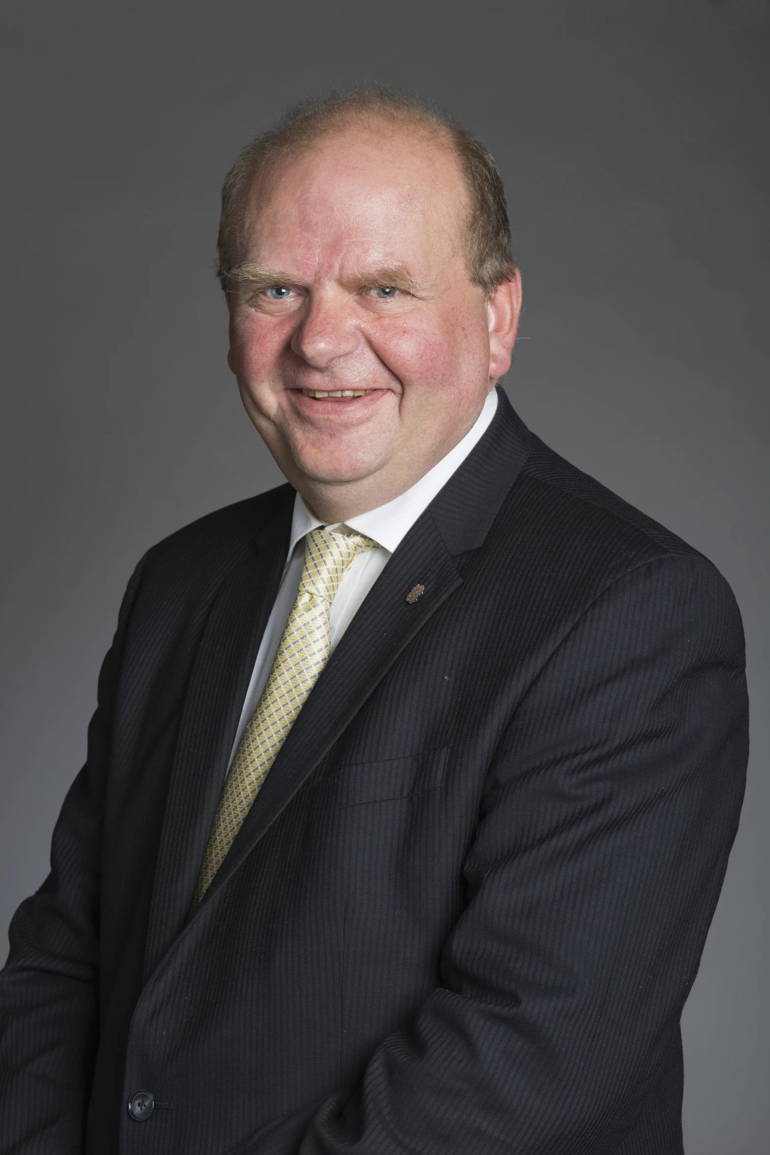 an old man with a gold tie and a suit