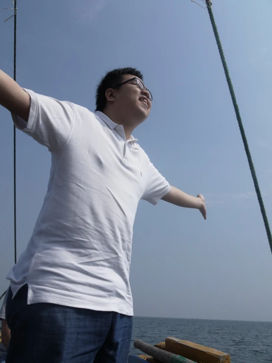 a man stands on the front deck of a boat