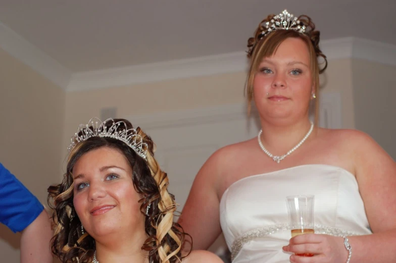 a woman wearing a tiara and holding a wine glass