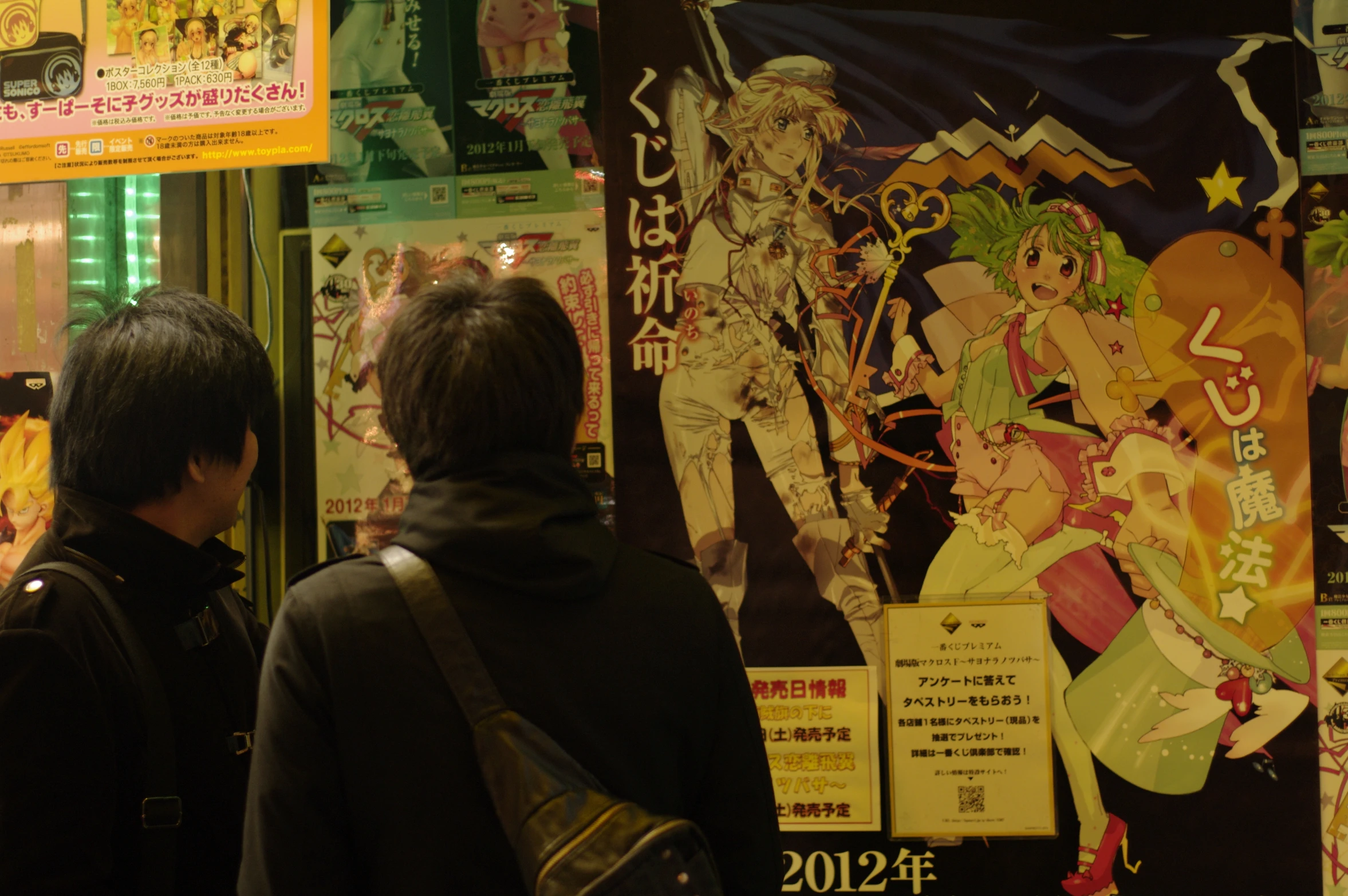 two people are looking at various anime images on a store wall