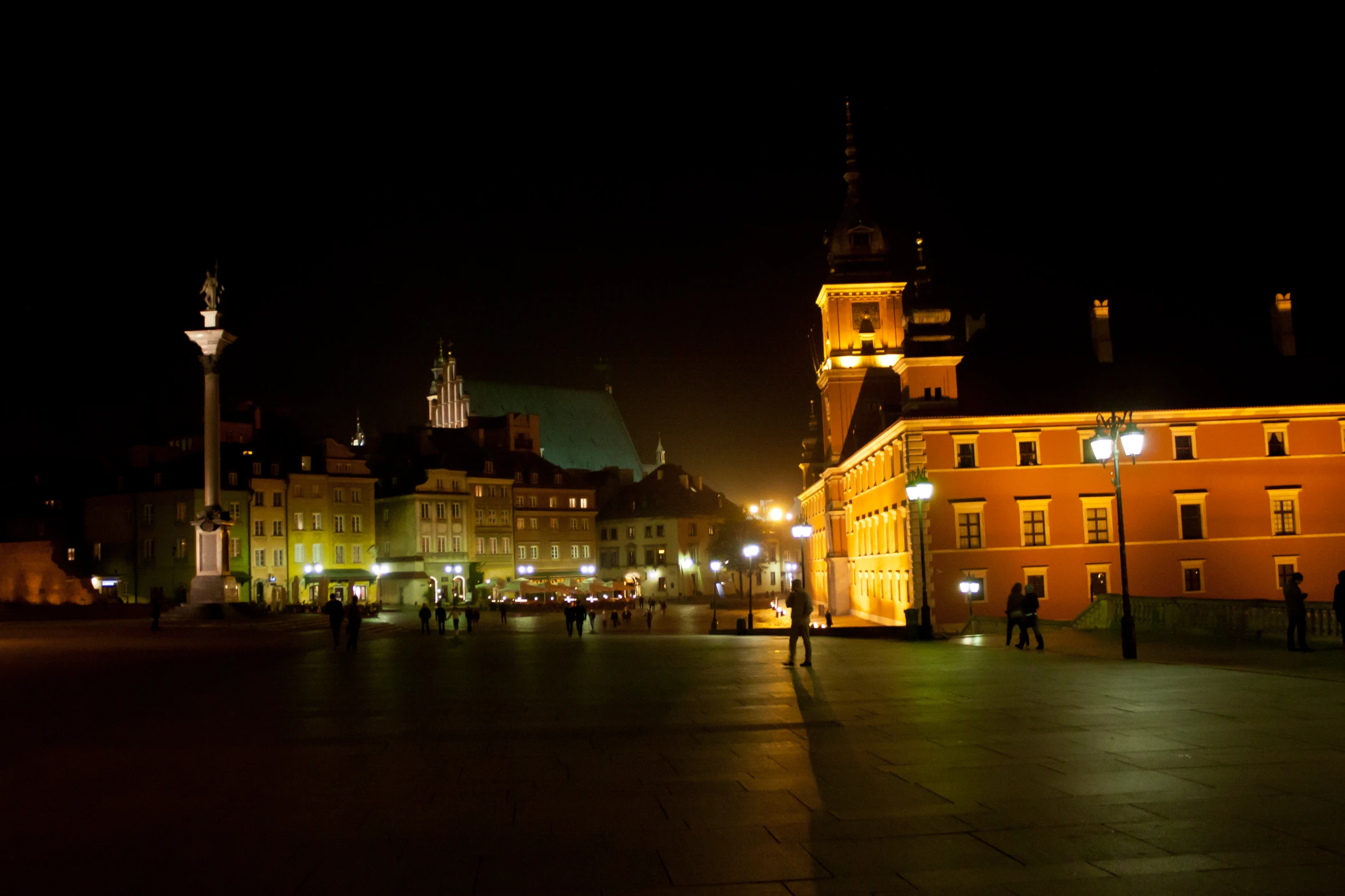 many people on a city sidewalk at night