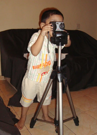 a small boy holding a camera in his hands