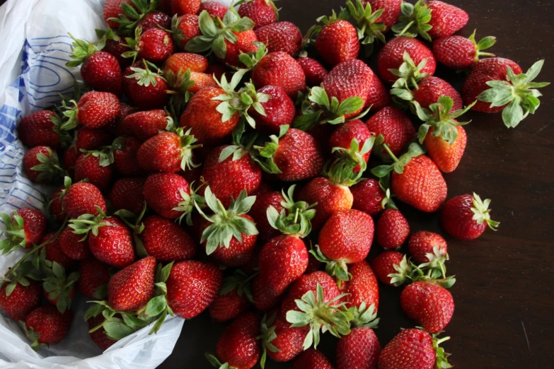 the bag is full of fresh strawberries and sits on a table