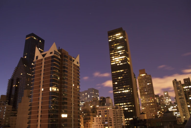 a view of the skyline at night, with skyscrs lit up in different colors