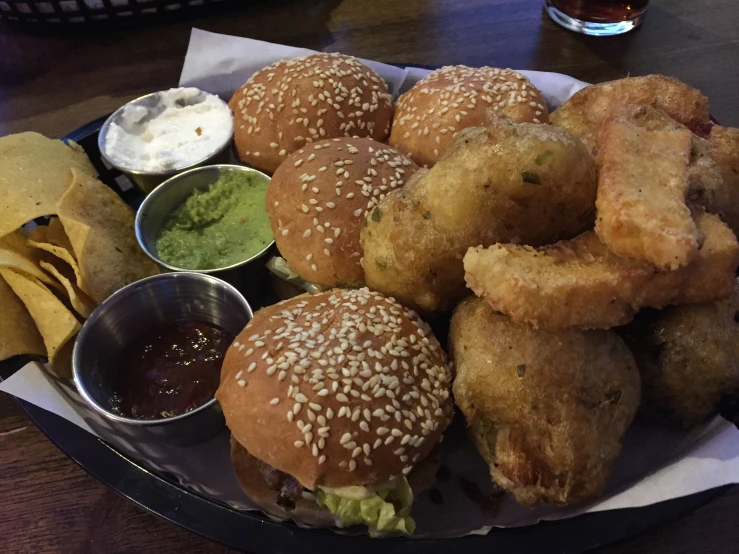 the tray of food is very tasty and has onion rings, breaded burgers, and dipping sauce