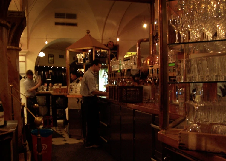 people standing in a bar with various glasses on display