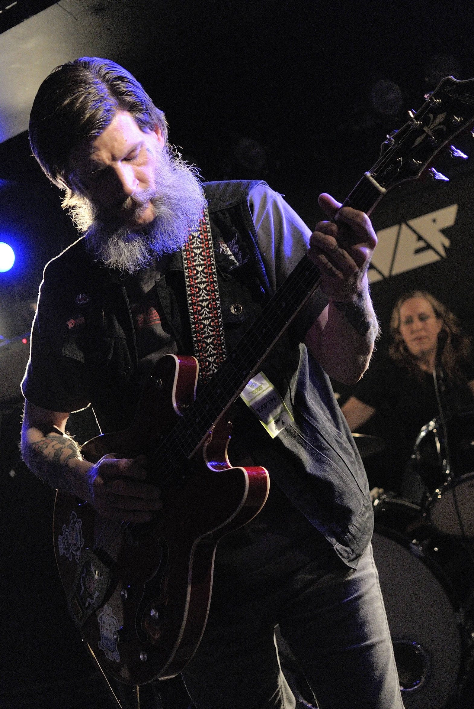 a man playing a guitar on stage with his band