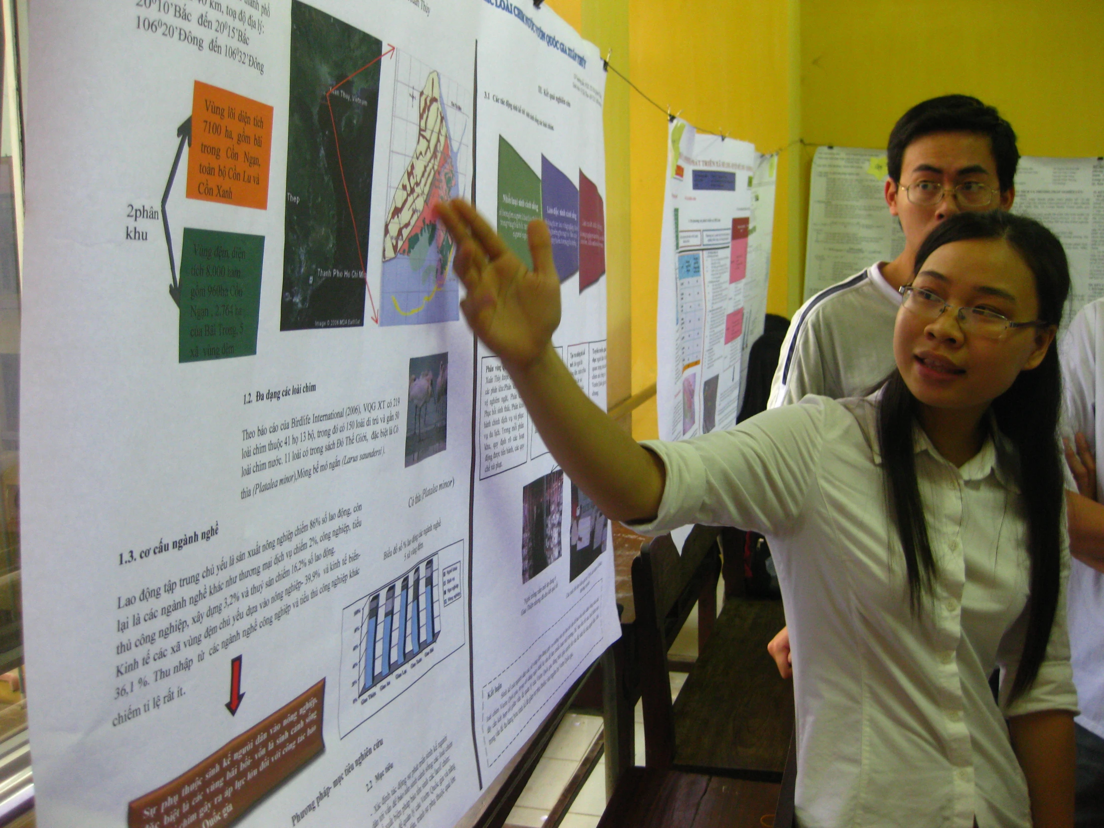 a woman pointing at a white board on display