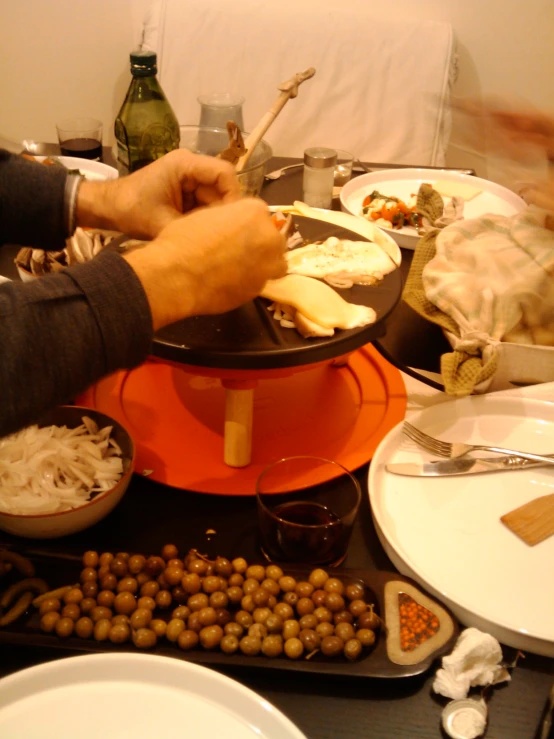 a person preparing food on top of a round table