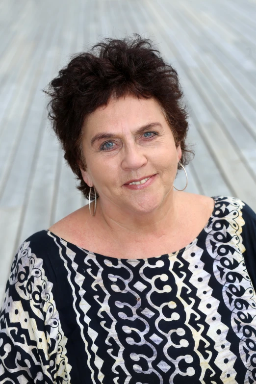 an older woman with short brown hair standing outdoors