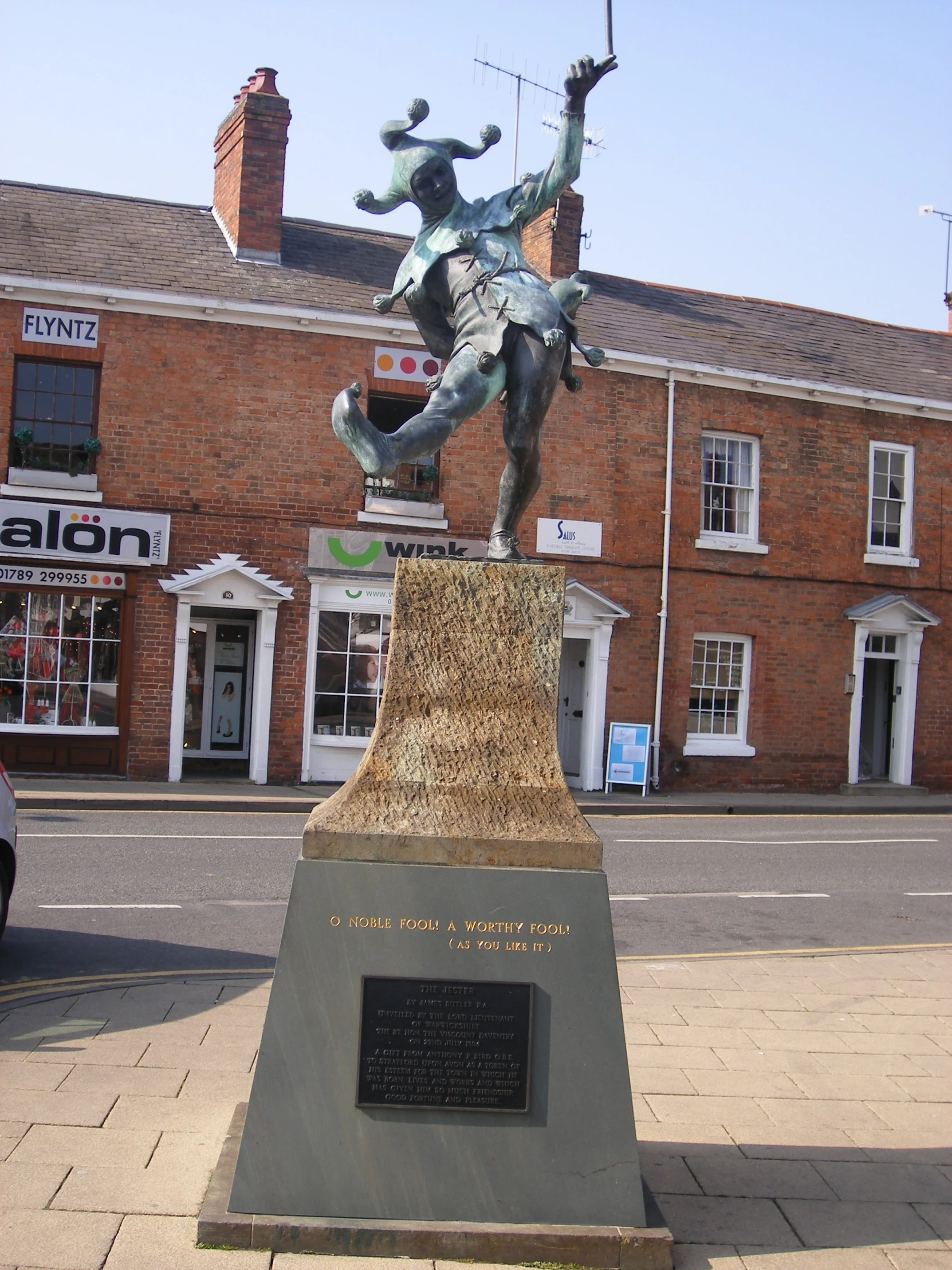 a statue of a girl riding a horse in a town square