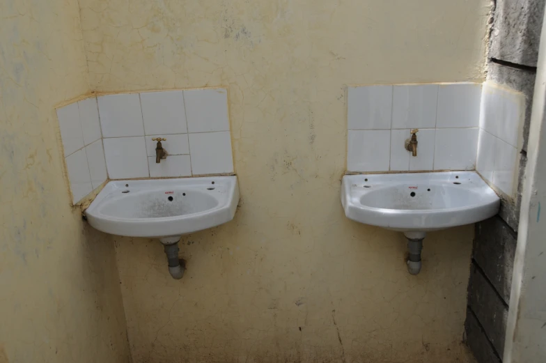 two small white ceramic sink basins in a bathroom