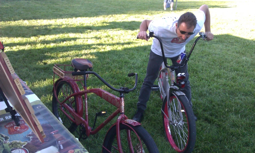 the man is riding a bicycle in a grassy area