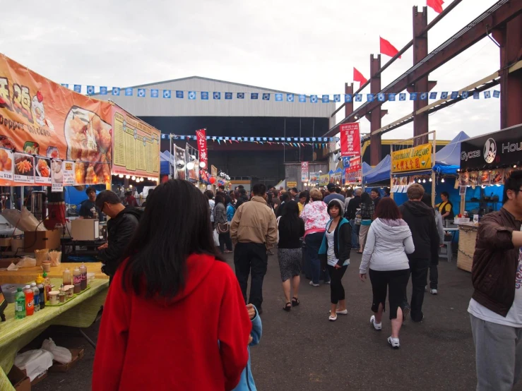 a group of people walking past a market