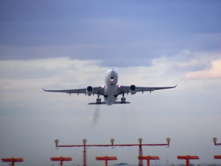 a plane that is flying by some red signs