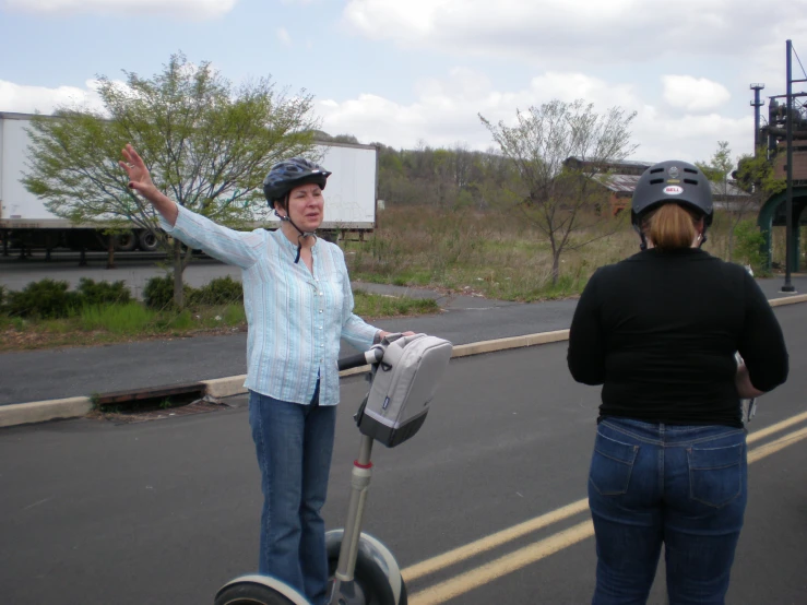 a woman waving while on her scooter and another woman talking to him