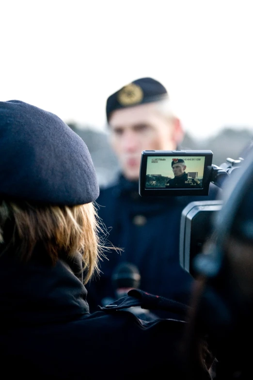 a television is being recorded by people as they stand next to each other