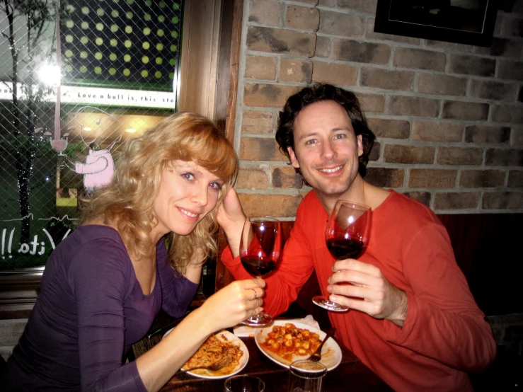 a man and woman drinking wine and food