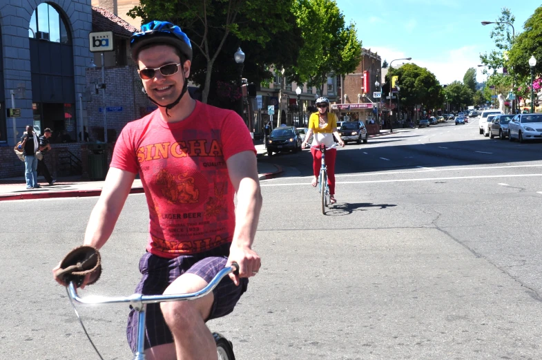 a man in red shirt on bike and woman in white