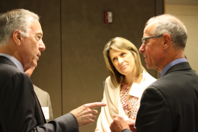 four adults standing next to each other talking