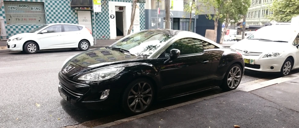 a picture of a black car that is parked on the side of a street