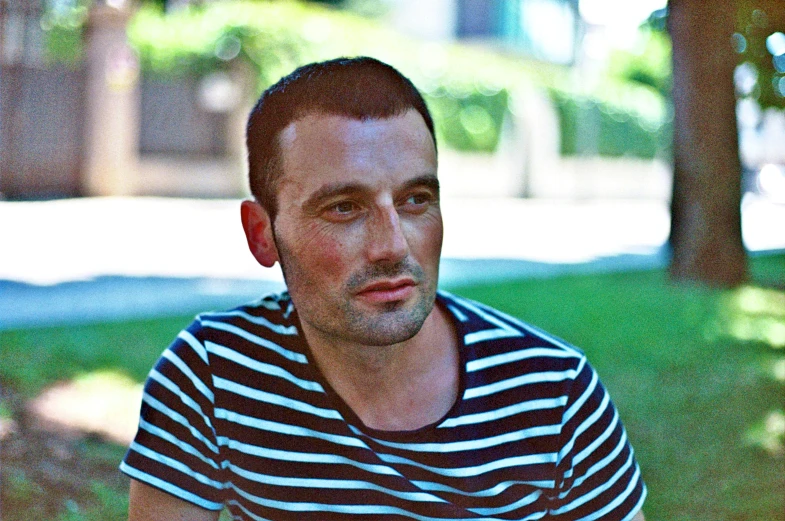 a man with striped shirt staring at soing