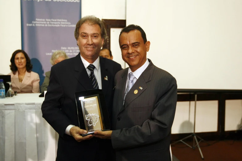 a man holds an award for his service to the public