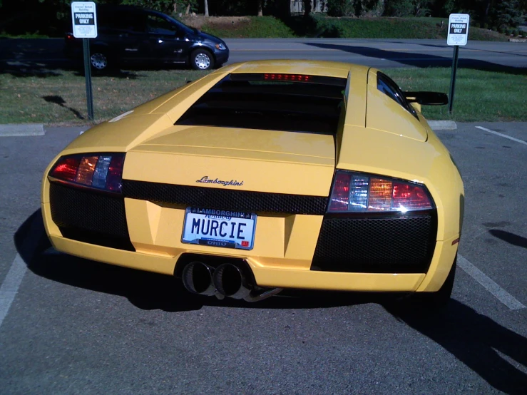 the back of a yellow sports car parked in the street