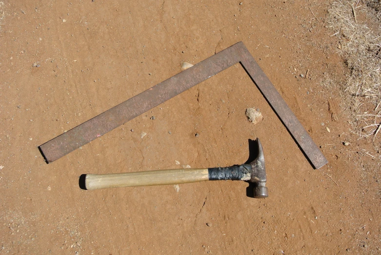 an old tool with two hammers, resting on ground