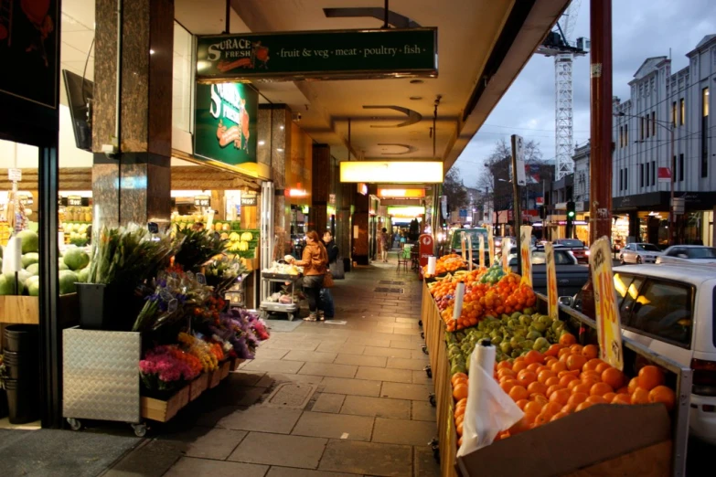 a city street with many baskets of fruit on the side