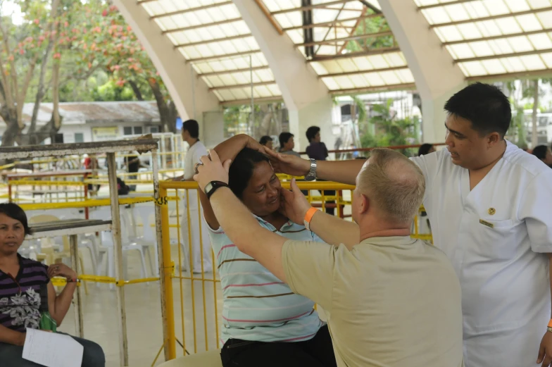 a woman getting her hair combed by a man with an instrument