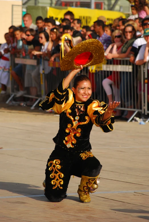 a girl in costume performing on the street with spectators watching