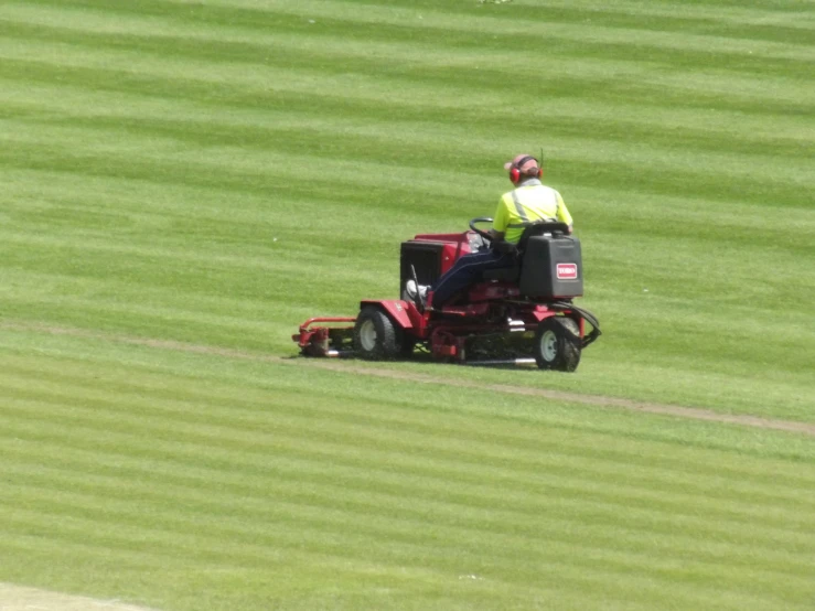 a man standing on top of a riding lawn mower