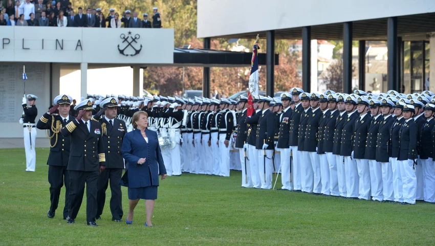 a woman standing next to a group of men in uniform