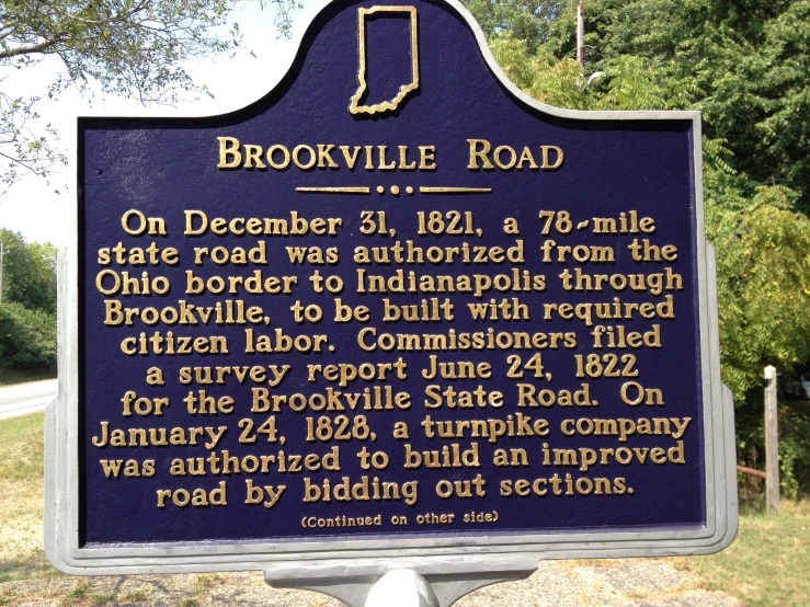 the historic plaque at bronkville road is in front of a house and trees