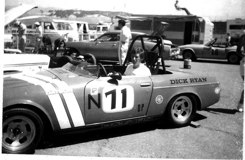 black and white po of two people in an old race car