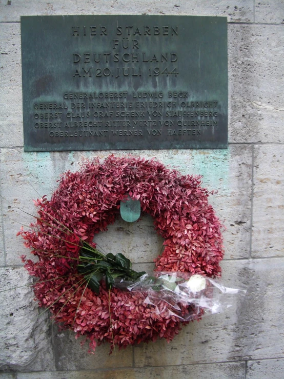 a wreath with a plaque in the background