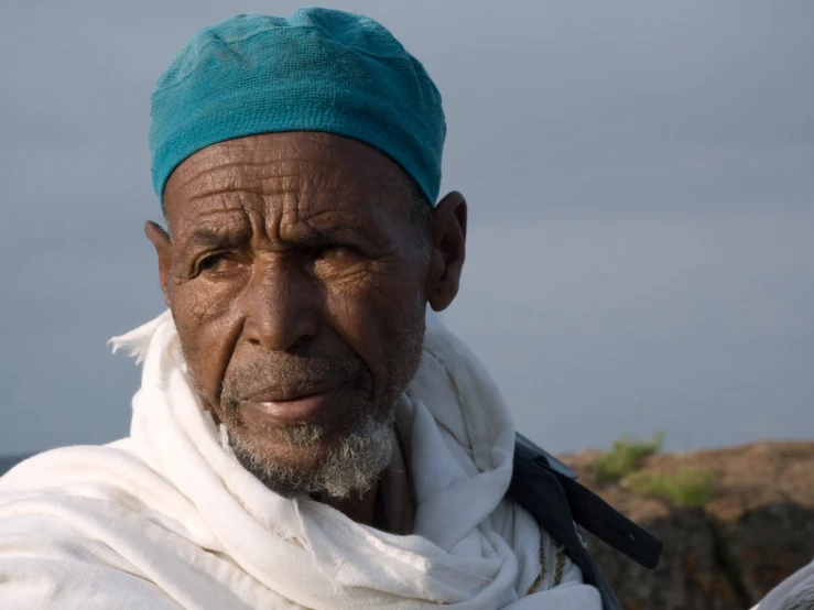 an old man with a blue turban on his head