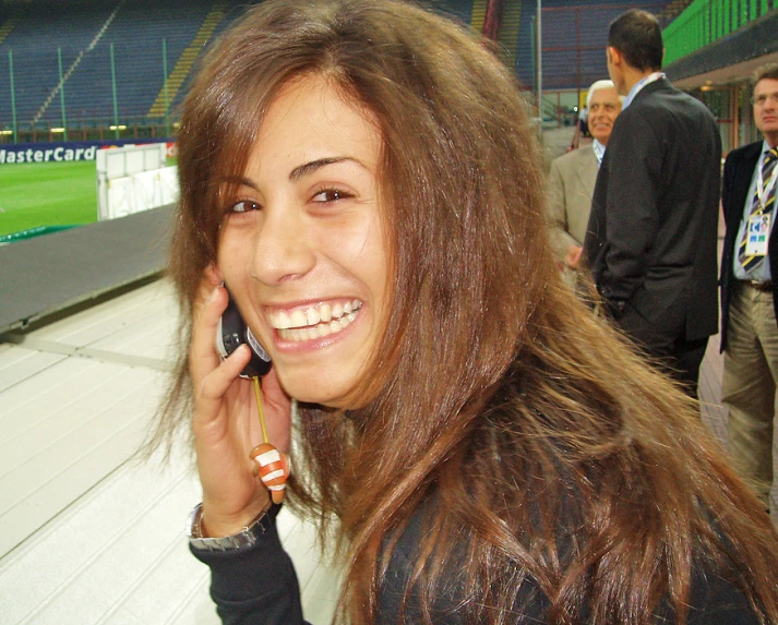 a women who is on a cell phone at a football game