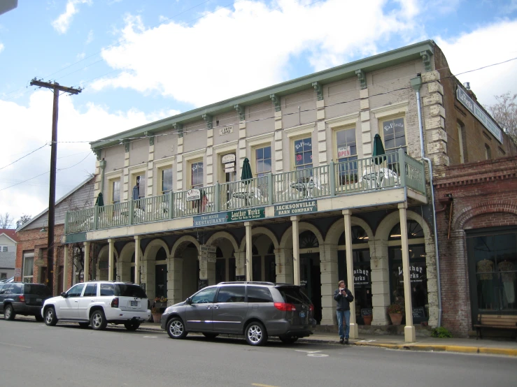 an old fashioned store with cars parked in front of it