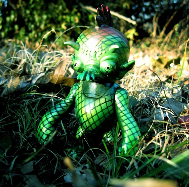 a little doll in the grass with green skin