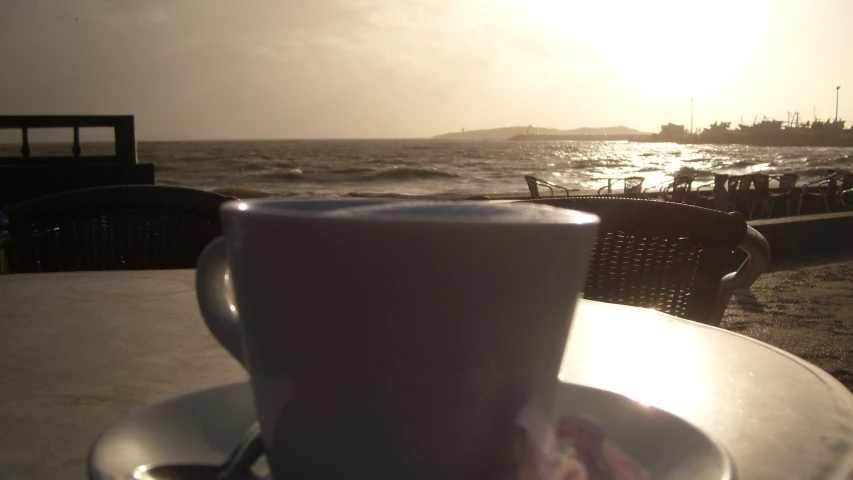 a cup of coffee sitting on top of a white table