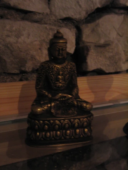 a statue of a buddha sits next to rocks